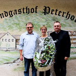 Peter Neidl, Kaufmännischer Leiter der Schlossbrauerei Naabeck (rechts), gratuliert den Wirtsleuten vom Peterhof mit einem Blumengeschenk für den Wechsel zur Schlossbrauerei Naabeck. Bild: L. Ehras 